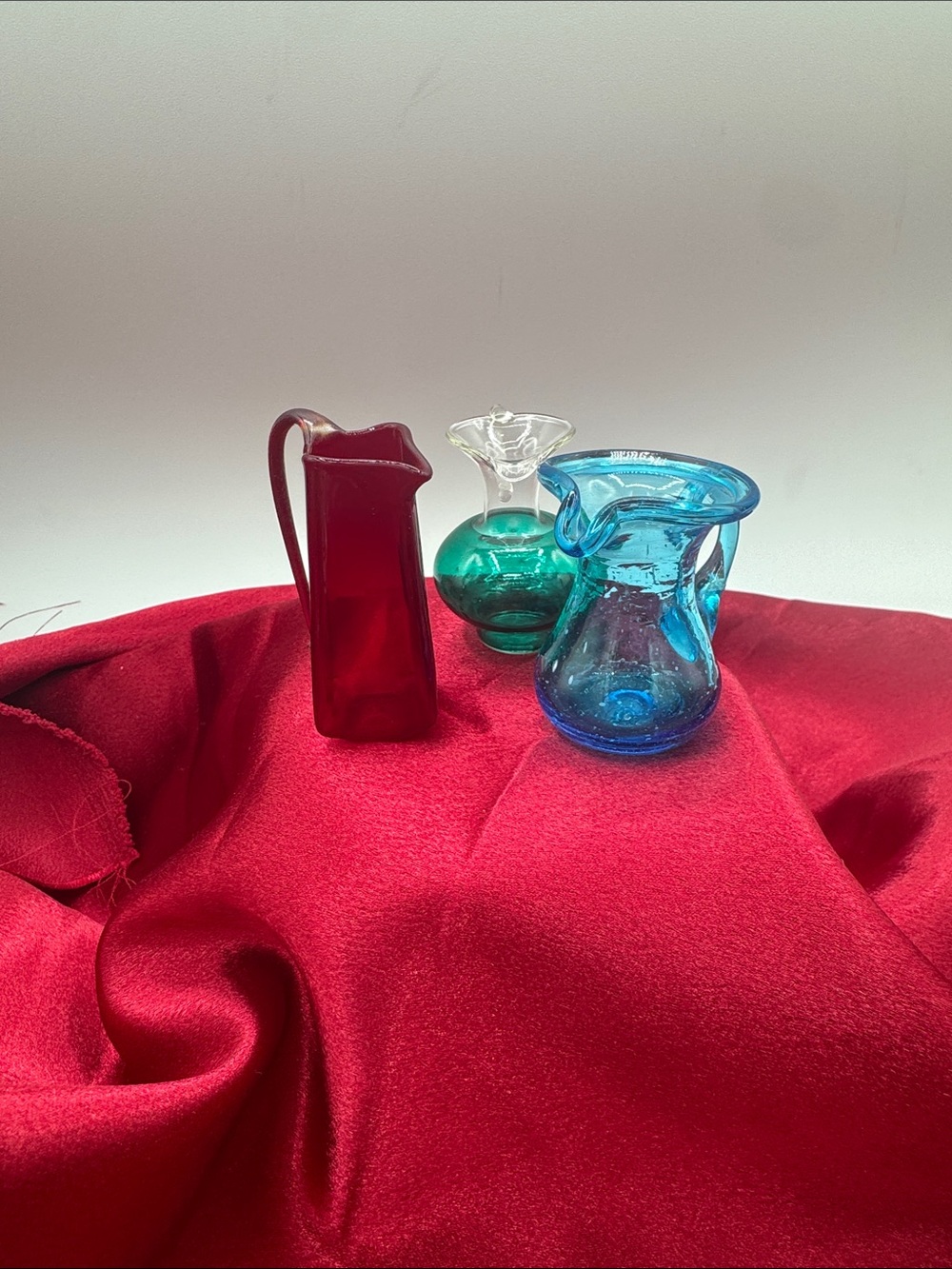 3 Miniature Blown Glass Pitchers; Teal/Clear, Ruby Red and Blue.
